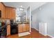 A kitchen featuring wooden cabinetry, black appliances, and hardwood floors at 1710 Grace Point Rd, Morrisville, NC 27560