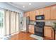 Open kitchen with stainless steel refrigerator, hardwood floors, and abundant cabinetry at 1710 Grace Point Rd, Morrisville, NC 27560