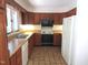 Functional kitchen with wood cabinets, neutral countertops, tile floor and modern appliances at 1812 Crepe Myrtle Dr, Sanford, NC 27330