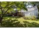 Backyard view of a brick home and storage shed, with a bicycle on the green lawn at 210 S Hughes St, Apex, NC 27502
