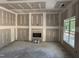 Spacious living room with fireplace installation and natural light from windows under construction at 214 Green Pines Estates Dr, Kenly, NC 27542
