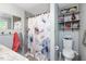 Bathroom featuring shower with decorative curtain, toilet, and storage shelves at 220 Cardinal Dr, Youngsville, NC 27596