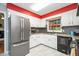 Bright kitchen with stainless steel refrigerator, white cabinets and dark appliances at 220 Cardinal Dr, Youngsville, NC 27596