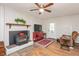 Cozy living room showcasing a fireplace, hardwood floors, and a ceiling fan at 220 Cardinal Dr, Youngsville, NC 27596