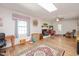Bright living room with hardwood floors, a white brick fireplace, skylight, and large area rug at 220 Cardinal Dr, Youngsville, NC 27596