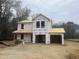 Under construction two story home with a two car garage and covered porch area surrounded by trees at 2554 Whitetail Rd, Nashville, NC 27856