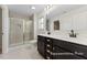 Elegant bathroom featuring a glass-enclosed shower, double vanity with dark cabinets, and neutral tile at 260 Curling Creek Dr # 235P, Clayton, NC 27527