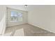 Bright bedroom featuring neutral walls, plush carpet, and natural light streaming through the window at 260 Curling Creek Dr # 235P, Clayton, NC 27527