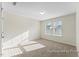 Well-lit bedroom with plush carpet and neutral walls, illuminated by natural light from the window at 260 Curling Creek Dr # 235P, Clayton, NC 27527