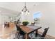 Bright dining area featuring a rustic wood table, modern chandelier, and views into the adjacent kitchen and living area at 260 Curling Creek Dr # 235P, Clayton, NC 27527