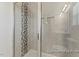 Tiled shower stall with glass enclosure, decorative mosaic tile accent, and adjustable shower head at 260 Curling Creek Dr # 235P, Clayton, NC 27527