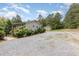 Exterior angle of the home with a gravel driveway, bushes, and a shed in the background at 2746 Saint Lukes Church Rd, Goldston, NC 27252
