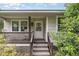 Charming front porch with weathered wood, black railings, rocking chairs, and bright white front door at 2746 Saint Lukes Church Rd, Goldston, NC 27252