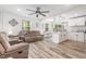 Open-concept living room showcasing hard wood floors, ceiling fan and seamless flow into dining and kitchen at 2746 Saint Lukes Church Rd, Goldston, NC 27252