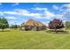 Sprawling lawn behind brick home, with manicured landscaping and mature trees at 296 Shoreline Dr, Princeton, NC 27569