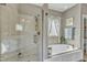 Elegant bathroom featuring a glass enclosed shower and soaking tub beneath a window at 296 Shoreline Dr, Princeton, NC 27569