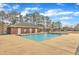 Community pool area showcasing a large in-ground pool and a brick building with multiple entry points at 296 Shoreline Dr, Princeton, NC 27569