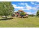 Sprawling brick home with a large front yard, mature trees, and lush landscaping for enhanced curb appeal at 296 Shoreline Dr, Princeton, NC 27569