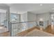 Elegant hallway with hardwood floors, decorative railing, and chandelier lighting at 296 Shoreline Dr, Princeton, NC 27569