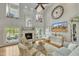 Bright living room with a fireplace, large windows, high ceilings and comfortable seating arrangements at 296 Shoreline Dr, Princeton, NC 27569