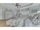 Bright main bedroom featuring a window seat, dresser with television, and a ceiling fan at 296 Shoreline Dr, Princeton, NC 27569