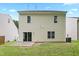 Home's backyard featuring a grassy lawn and a two-story exterior with several windows and a sliding glass door at 3223 Polite Ln, Raleigh, NC 27610