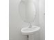 Bathroom features an oval mirror above a pedestal sink with chrome faucet and towel ring at 3223 Polite Ln, Raleigh, NC 27610