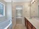 Bright bathroom boasts soaking tub, cherry vanity with granite countertops, and tile flooring at 3223 Polite Ln, Raleigh, NC 27610