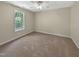 Neutral bedroom with carpet flooring, ceiling fan, and a large window at 3223 Polite Ln, Raleigh, NC 27610