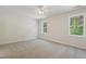 Spacious bedroom with neutral carpet, two windows overlooking a lush green yard and ceiling fan at 3223 Polite Ln, Raleigh, NC 27610