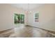 Dining area with hardwood floors, chandelier, sliding glass door, and large window at 3223 Polite Ln, Raleigh, NC 27610