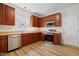 Well-lit kitchen with stainless appliances, wood cabinets, and hardwood floors at 3223 Polite Ln, Raleigh, NC 27610