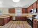 Well-lit kitchen featuring stainless steel appliances, and plenty of dark wood cabinets at 3223 Polite Ln, Raleigh, NC 27610