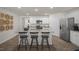 Modern kitchen with granite countertops, stainless steel appliances, white cabinets, and island seating at 3608 Sorda Ct, Raleigh, NC 27610