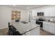 Contemporary kitchen featuring granite counters, island seating, white cabinetry, and stainless steel appliances at 3608 Sorda Ct, Raleigh, NC 27610