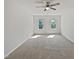 A bright bedroom with neutral carpeting, large windows, and a ceiling fan at 3705 Cassaro Ln, Zebulon, NC 27597