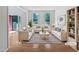 Bright living room with hardwood floors, white sofas, striped rug, and open entrance at 3705 Cassaro Ln, Zebulon, NC 27597
