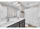 Modern bathroom with double sinks, vanity, and tiled floors and shower with a white curtain at 4024 Dunkirk Dr, Burlington, NC 27215