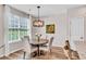 Charming dining area featuring a round wooden table, elegant lighting, and views of the landscaped yard at 4024 Dunkirk Dr, Burlington, NC 27215