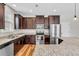 Modern kitchen with granite counters, stainless steel appliances, and dark wood cabinets for ample storage at 4024 Dunkirk Dr, Burlington, NC 27215