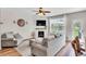 Comfortable living room featuring a cozy fireplace, large windows and hardwood floors is ideal for relaxing and entertaining at 4024 Dunkirk Dr, Burlington, NC 27215