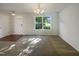 Bright living room featuring a large window, neutral walls and flooring, and modern lighting at 4126 Amber Stone Way, Durham, NC 27704