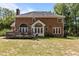 Backyard features a spacious brick home with a deck, expansive lawn and mature trees at 4225 Old Lewis Farm Rd, Raleigh, NC 27604