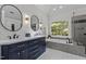 Elegant bathroom with double vanity, modern fixtures, soaking tub, and backyard view at 4225 Old Lewis Farm Rd, Raleigh, NC 27604
