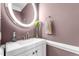 Stylish powder room with a modern vanity, decorative mirror, and a towel ring at 4225 Old Lewis Farm Rd, Raleigh, NC 27604