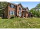 Beautiful two-story brick home featuring black shutters, a well-manicured lawn and manicured flower beds at 4225 Old Lewis Farm Rd, Raleigh, NC 27604