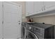 Convenient laundry room with modern washer and dryer, storage cabinets, and access to the exterior at 4225 Old Lewis Farm Rd, Raleigh, NC 27604