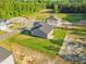 Aerial view showcasing the layout of gray homes with vast grassy areas at 482 Olivia Crossing Ct, Four Oaks, NC 27524