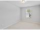 A bright, empty bedroom with carpet floors, white walls, and a window at 482 Olivia Crossing Ct, Four Oaks, NC 27524
