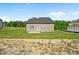 Exterior rear view of home with large yard and partial view of wooded area at 482 Olivia Crossing Ct, Four Oaks, NC 27524